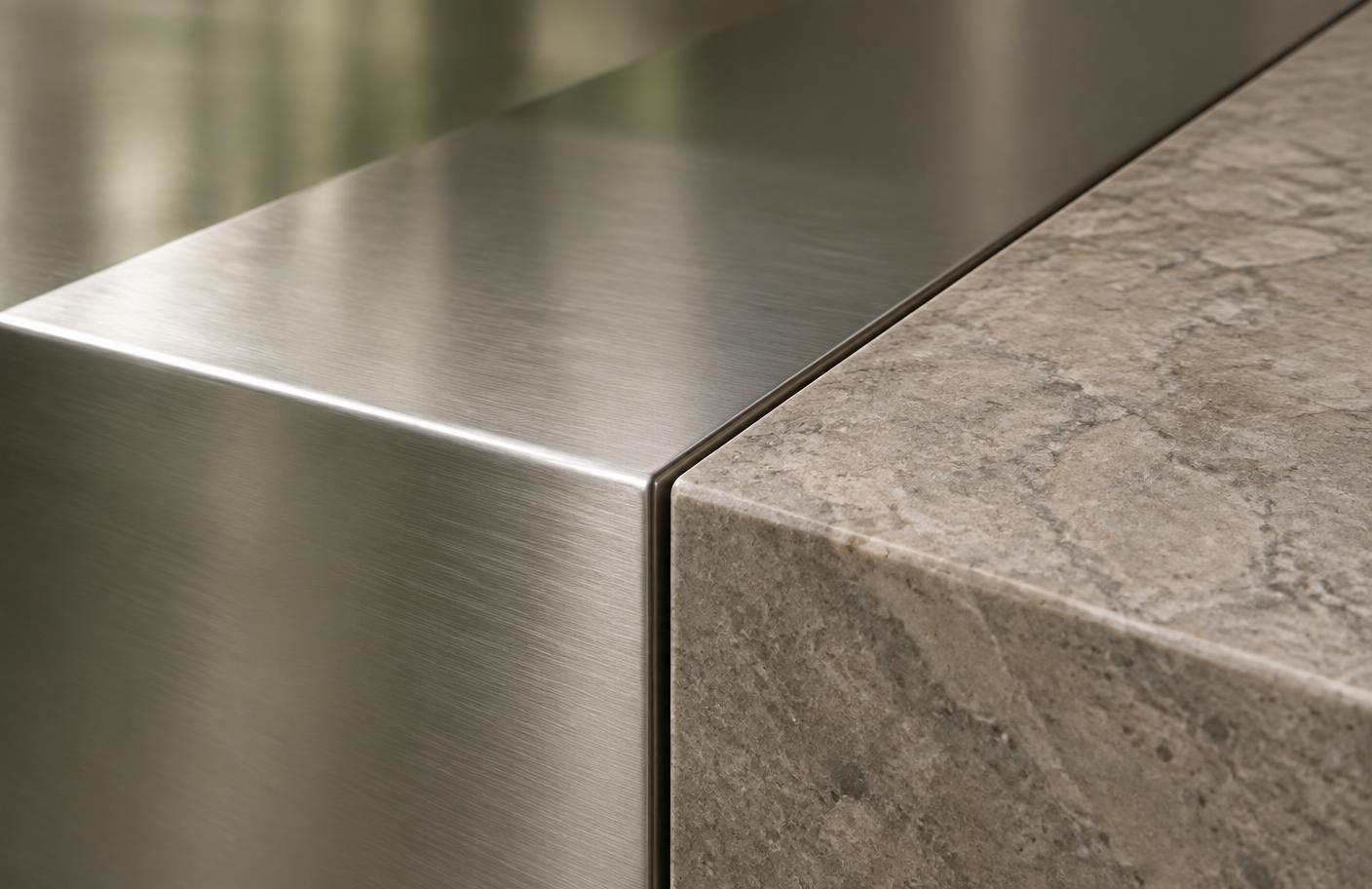 Brushed metal meeting a warm stone edge